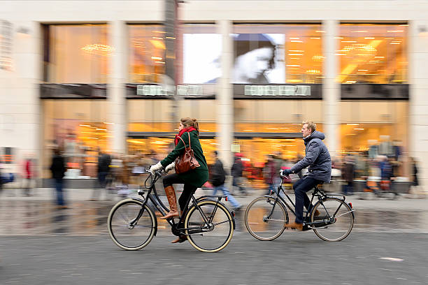 Vienna, Austria - May 23, 2016: Bicyclists and people shopping in Mariahilferstrasse, street in Vienna, Austria