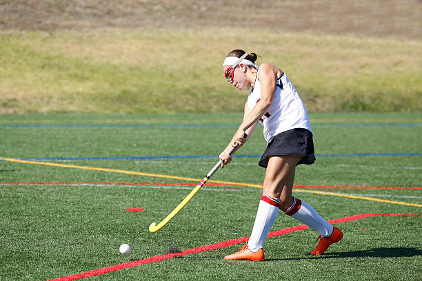 Field Hockey Hit a girl hits a field hockey ball basketball sport photos stock pictures, royalty-free photos & images