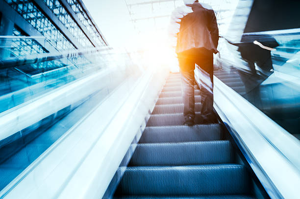 istock Businessman standing on escalator 495902650