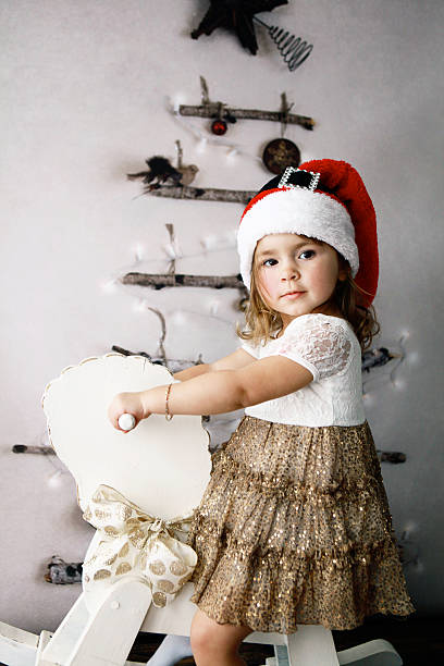 istock Child on Rocking Horse by Christmas Tree 495902840