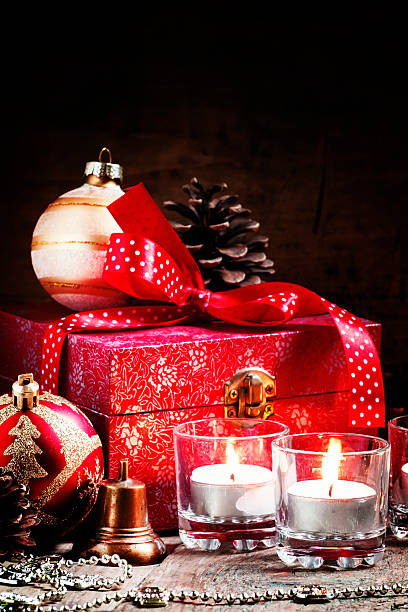 istock Burning candles and red box with gifts, pine cones 495906192
