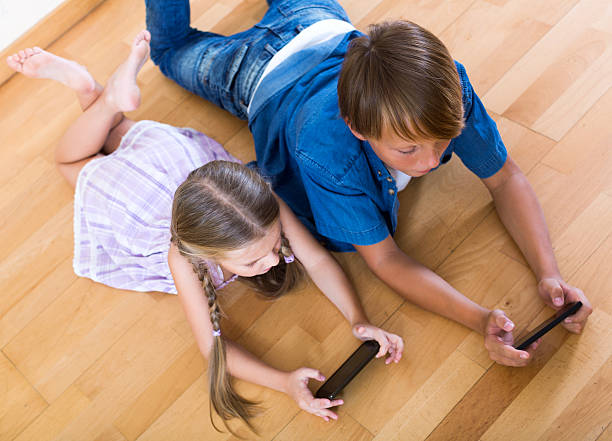 istock Positive siblings playing with phones 495906744