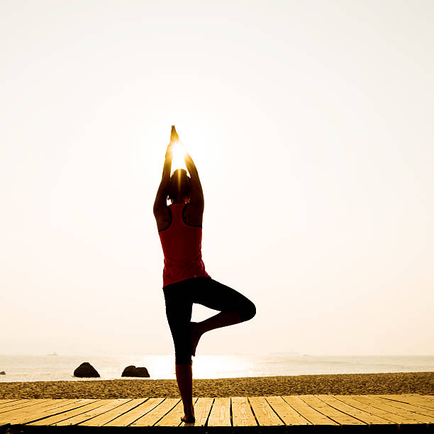 istock Woman in yoga pose at beach 495907368