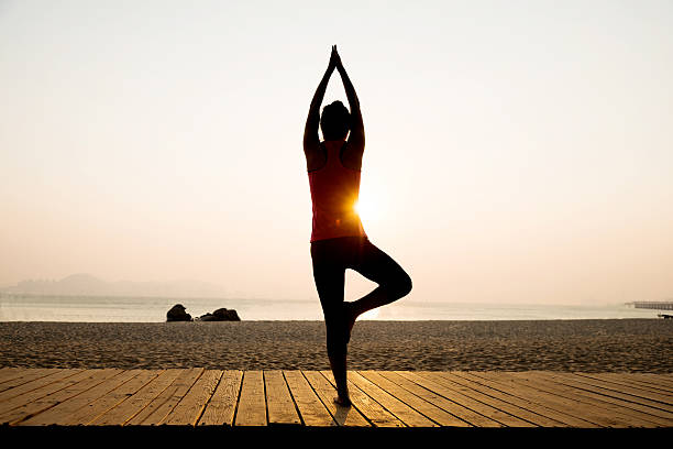 istock Woman in yoga pose at beach 495907440