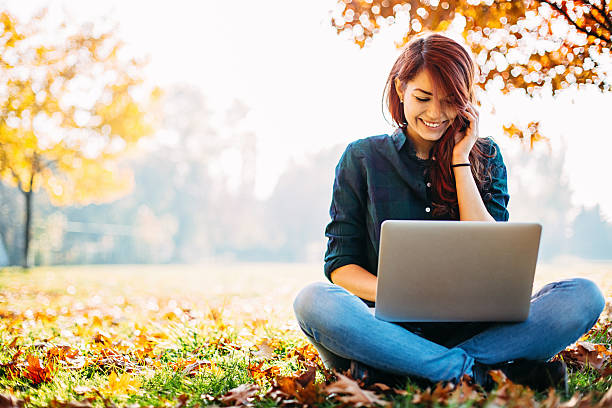少女とコンピュータの秋 - nature smiling teenage girls female ストックフォトと画像