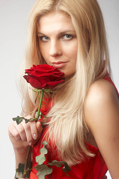 istock beautiful young women with red rose 495910250