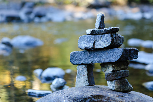 inukshuk on river with maple leaf