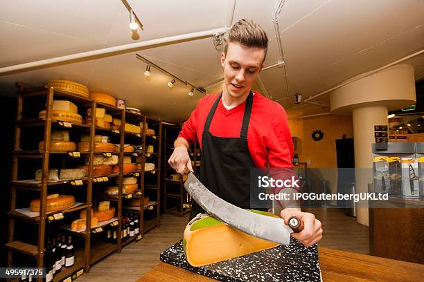 Young Store Clerk Cutting Cheese At Counter Stock Photo - Download Image Now - 18-19 Years, Adult, Adults Only