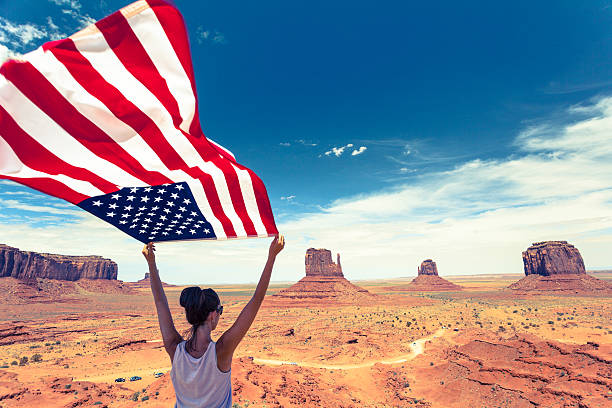 mulher segurando a bandeira americana eua em monument valley, de referência - extreme terrain arizona desert mesa imagens e fotografias de stock