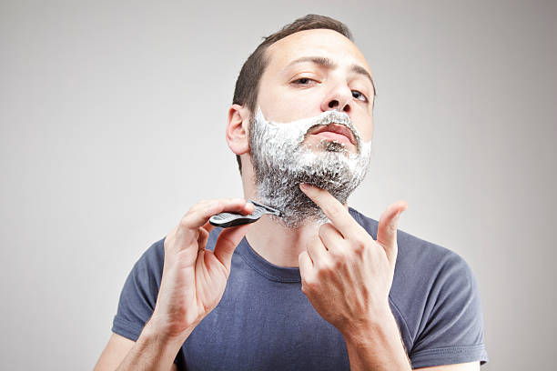 Young man shaving stock photo