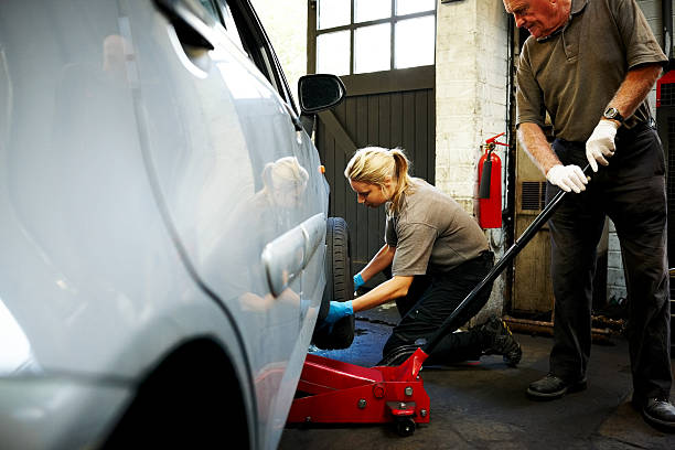 female 정비공 변화하는 타이어 in 거라지 - tire car built structure surrogate 뉴스 사진 이미지