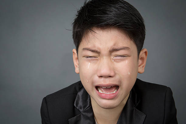 istock Little asian boy in black suit upset, depression face 495927432