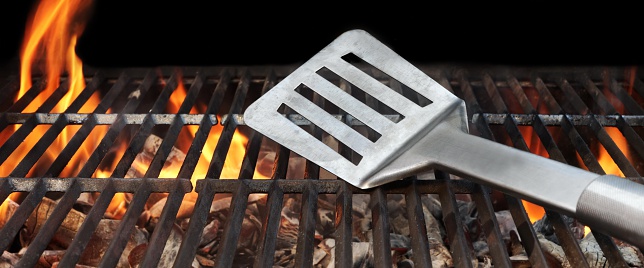 BBQ Grill And Spatula. Flame Of Fire In The Background.