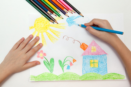 Child draws a pencil drawing of the world