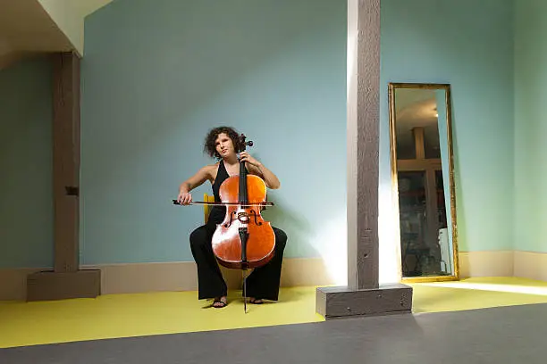 young girl playing cello in a room