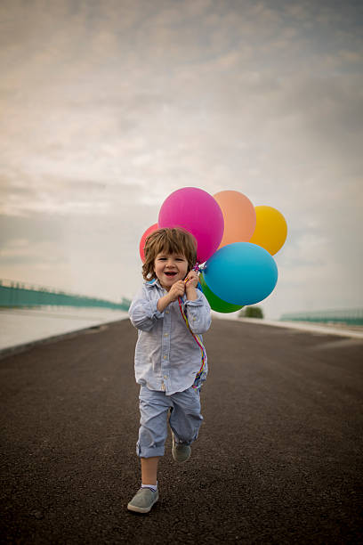 陽気な少年ランニング、色とりどりの風船。 - child balloon outdoors little boys ストックフォトと画像
