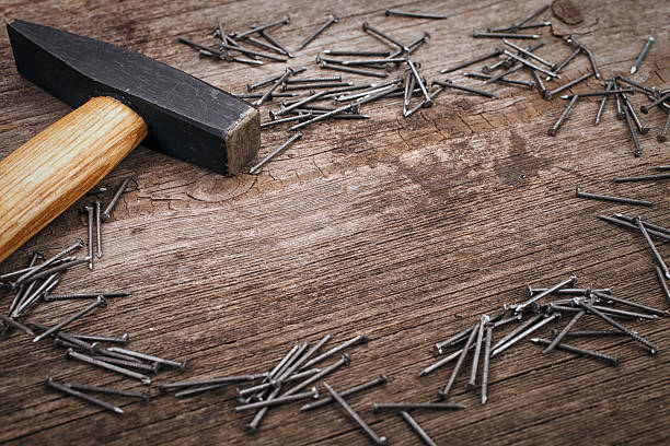 istock metal Hammer and nails on wooden board 495930722