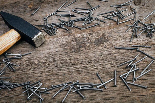 istock metal Hammer and nails on wooden board 495932304
