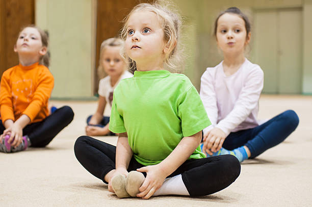 Kids doing exercise in gym stock photo