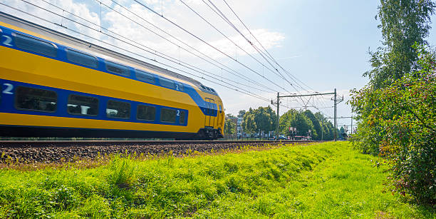 passenger train driving at high speed in summer - trein nederland stockfoto's en -beelden