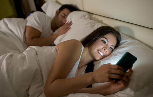 woman social networking  in bed - kvinna telefonbedragare bildbanksfoton och bilder