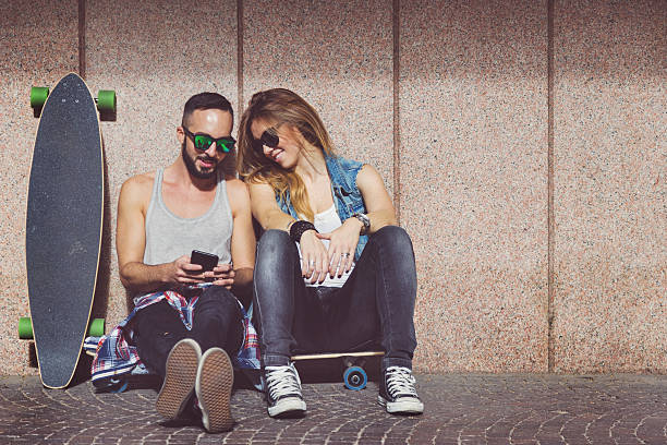 istock Young skaters resting and social networking with mobile 495950996
