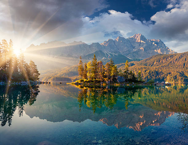Misty summer morning on the Eibsee lake in German Alps.