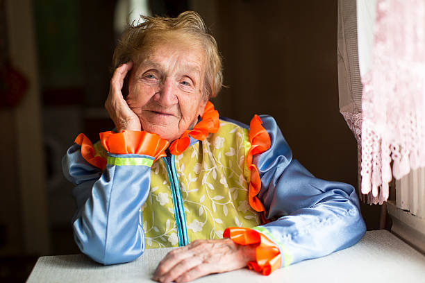 istock Old woman in ethnic slavic clothes sitting at a table 495951988
