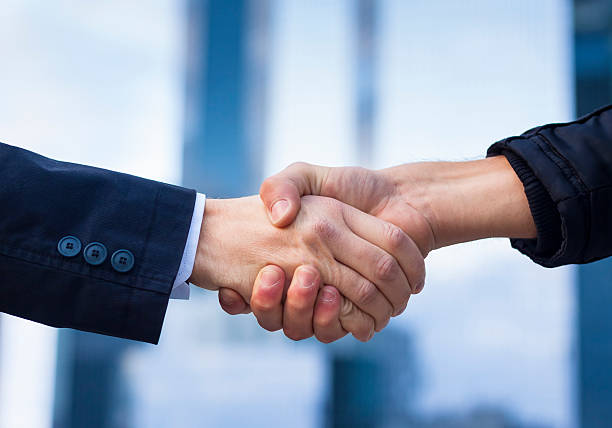 dois homens de negócios apertar mãos - stability agreement handshake human hand - fotografias e filmes do acervo