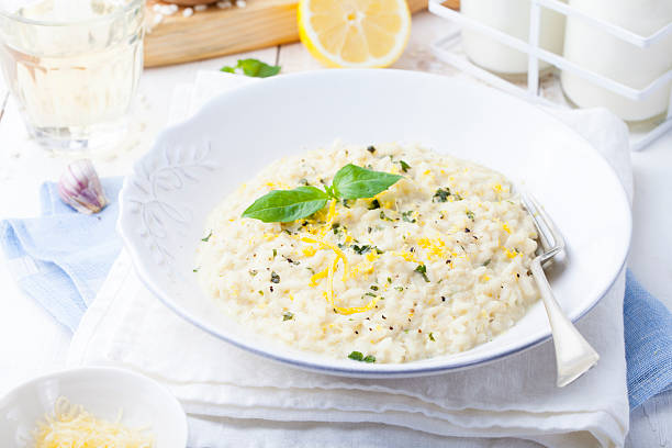 risotto z cytryna i świeża bazylia. białe, drewniane tle - parmesan cheese risotto rice basil zdjęcia i obrazy z banku zdjęć