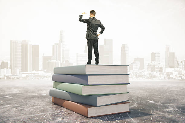 istock Businessman standing on a pile of books, learning concept 495959616