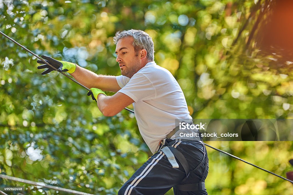 so hard to get in the top side view of sportive man in adventure park walking, passing through the obstacles and enjoying his outdoor adventure. 2015 Stock Photo