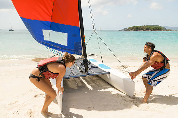 istock young couple pulling the catamaran on a tropical beach 495978728