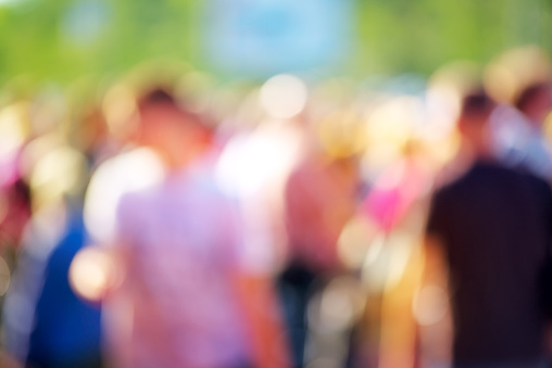 Blur crowd of people at public outdoors place or gathering, social event background, vivid colors, defocus image.