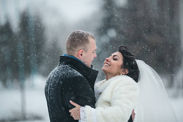 istock Bride and groom walking in the snow 495984128