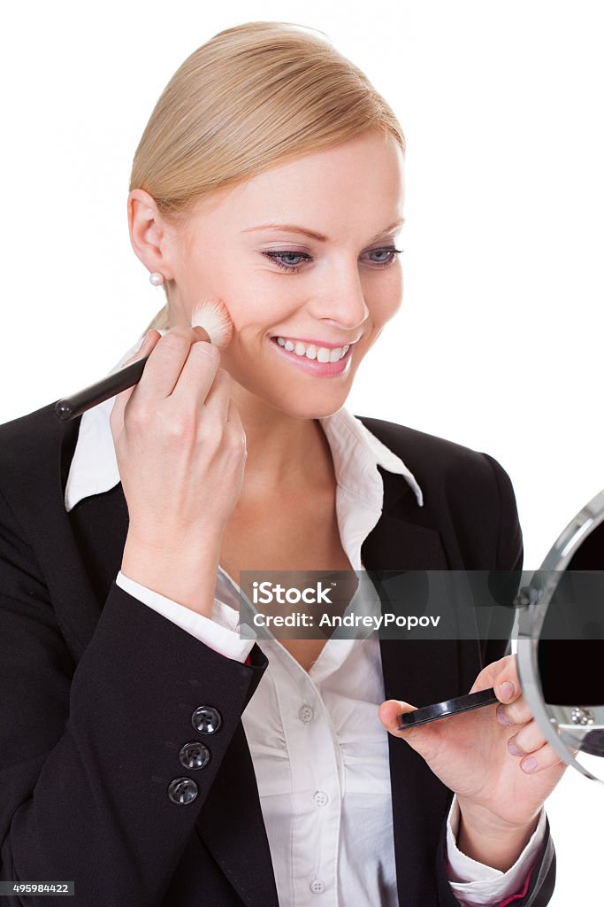 Attractive businesswoman applying foundation Attractive businesswoman applying foundation. Isolated on white 2015 Stock Photo