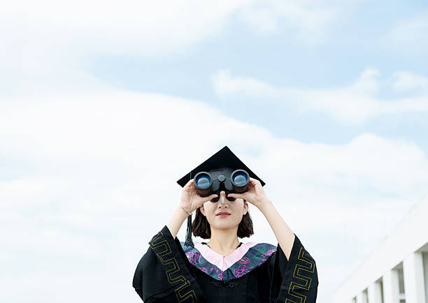 Close-Up Portrait Of Young Man Wearing Mortarboard Against White Background