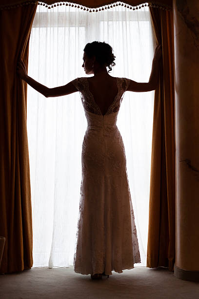 istock Silhouete of a bride standing by the window 495988106