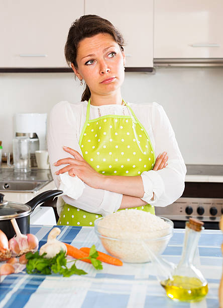 istock Pensive woman cooks rice with vegetables 495988386