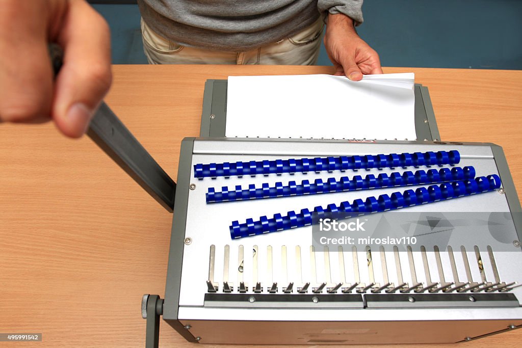 male man binding pages at table in paper store 2015 Stock Photo