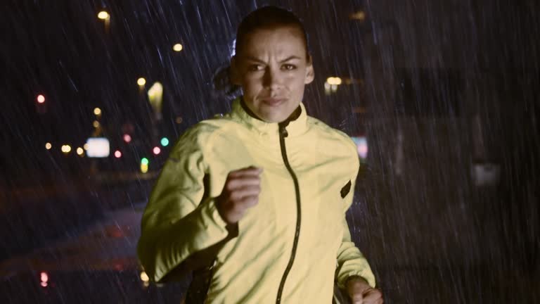 SLO MO TS Woman running in the city on a rainy night