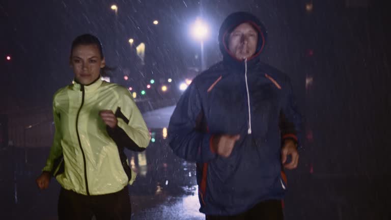 SLO MO TS Couple running in city streets at night