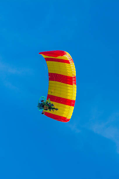 istock red and yellow powered tandem para glider flying 496029150