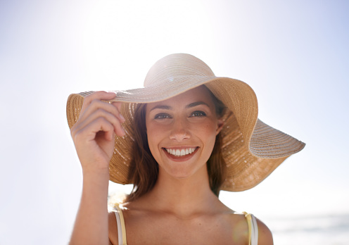 Portrait of preschool girl with straw hat. Cute happy toddler child looking at the camera and smiling. Lovely girl on summer vacations with family