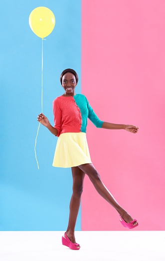 Studio shot of a stylish young woman holding a yellow balloon against a colorful backgroundhttp://195.154.178.81/DATA/i_collage/pi/shoots/783402.jpg