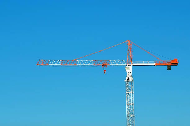istock Red and White Tower Crane Against Blue Sky 496032570
