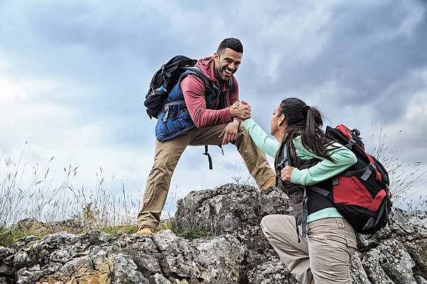 hombre y mujer ayuda on the rocks - aspirations mountain hiking climbing fotografías e imágenes de stock