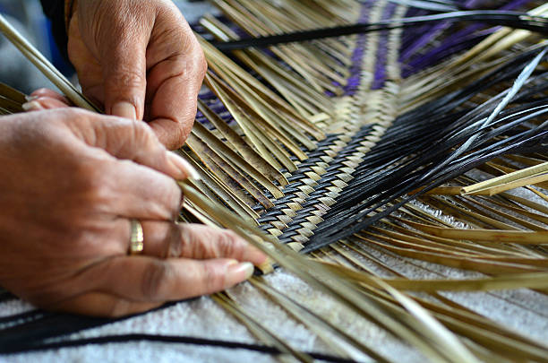 Maori woven artwork Hands of an old Maori woman weaving a traditional Maori woven artwork. weaverbird photos stock pictures, royalty-free photos & images