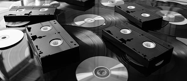 istock VHS video tapes with DVD CD discs on vinyl records 496033396