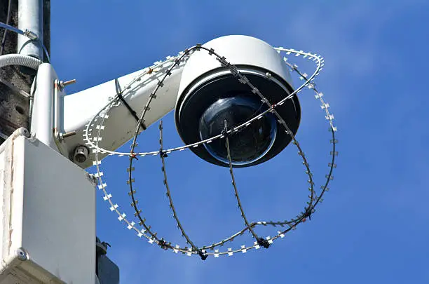 One security surveillance camera protected with barbed wire against vandalism and crime. concept photo of security.